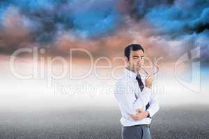 Composite image of thinking businessman holding glasses