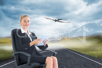 Composite image of businesswoman sitting on swivel chair with ta