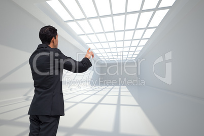 Composite image of thoughtful asian businessman pointing