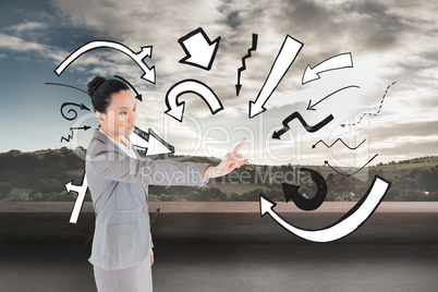 Composite image of unsmiling asian businesswoman pointing