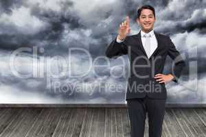 Composite image of smiling asian businessman pointing