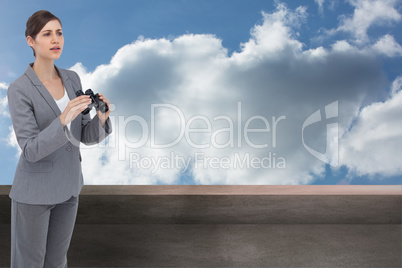 Composite image of curious young businesswoman with binoculars