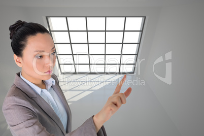 Composite image of unsmiling asian businesswoman pointing