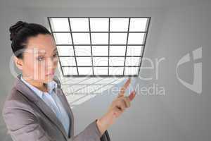 Composite image of unsmiling asian businesswoman pointing