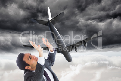 Composite image of unsmiling businessman with arms raised