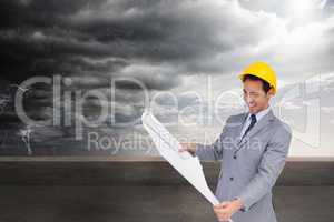 Composite image of smiling architect with hard hat looking at pl