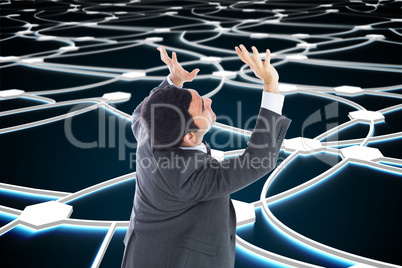 Composite image of unsmiling businessman with arms raised