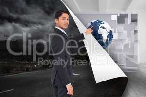 Composite image of serious asian businessman pointing