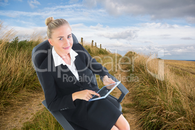 Composite image of businesswoman sitting on swivel chair with ta