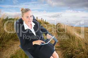 Composite image of businesswoman sitting on swivel chair with ta