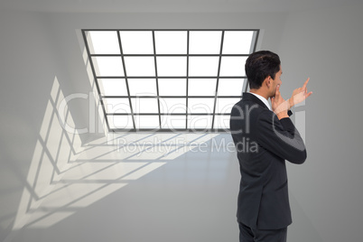 Composite image of thoughtful asian businessman pointing