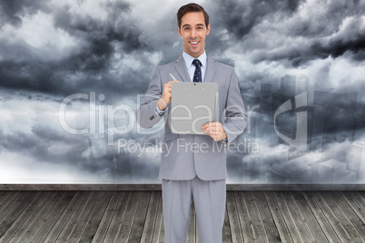 Composite image of happy businessman holding a clipboard