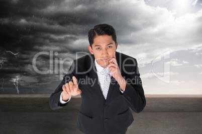 Composite image of thoughtful asian businessman pointing