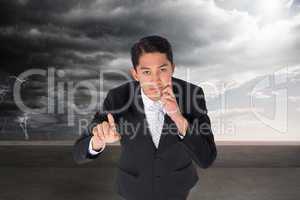 Composite image of thoughtful asian businessman pointing