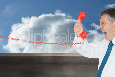 Composite image of businessman screaming directly into the hands