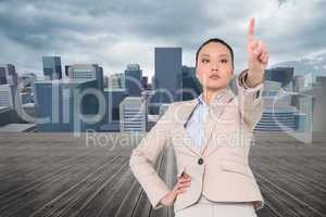 Composite image of unsmiling asian businesswoman pointing