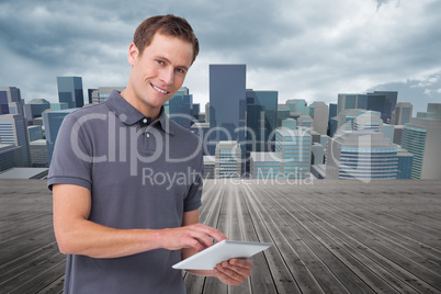 Composite image of smiling young man with tablet computer