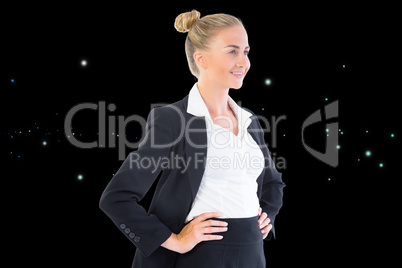 Composite image of businesswoman standing with hands on hips