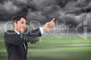 Composite image of smiling asian businessman pointing