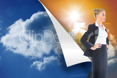 Composite image of businesswoman standing with hands on hips