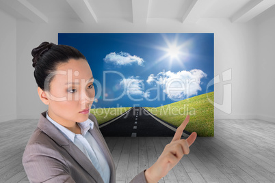 Composite image of unsmiling asian businesswoman pointing