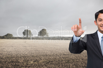 Composite image of smiling asian businessman pointing