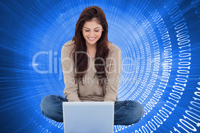 Composite image of brunette sitting on floor using laptop