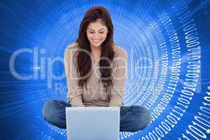 Composite image of brunette sitting on floor using laptop