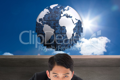 Composite image of thoughtful asian businessman pointing