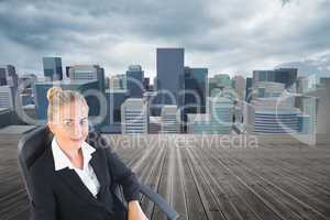 Composite image of businesswoman sitting on swivel chair with la