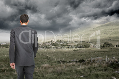 Composite image of young businessman walking away from camera