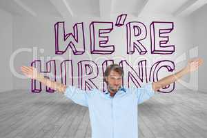 Handsome man raising arms in front of were hiring graphic