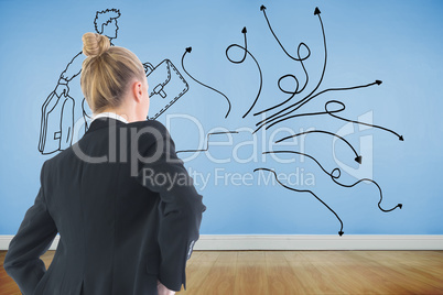 Composite image of businesswoman standing with hands on hips