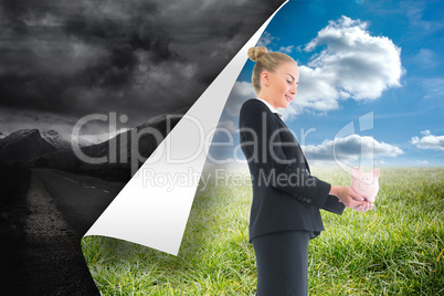 Composite image of businesswoman holding pink piggy bank