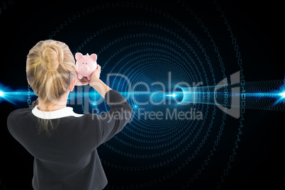 Composite image of businesswoman holding pink piggy bank