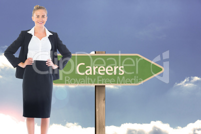 Composite image of businesswoman standing with hands on hips