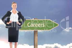 Composite image of businesswoman standing with hands on hips