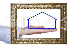 outstretched hand behind photo frame with house