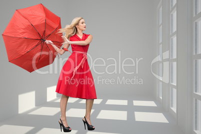 Composite image of beautiful woman posing with a broken umbrella