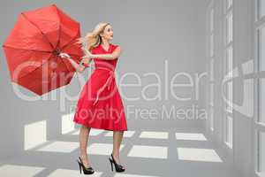 Composite image of beautiful woman posing with a broken umbrella
