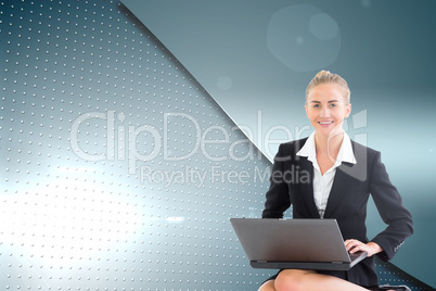 Composite image of businesswoman using laptop