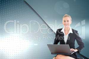 Composite image of businesswoman using laptop