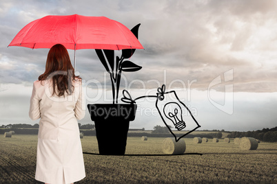 Composite image of businesswoman standing back to camera holding