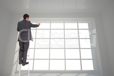 Composite image of businessman standing on ladder