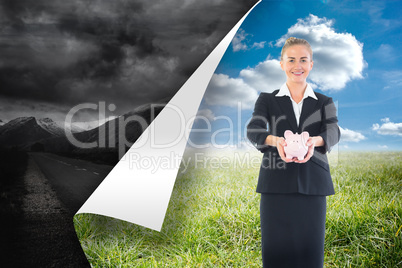 Composite image of happy businesswoman holding a piggy bank