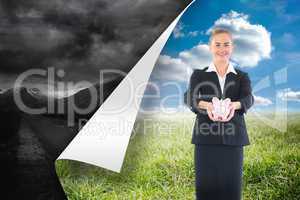 Composite image of happy businesswoman holding a piggy bank