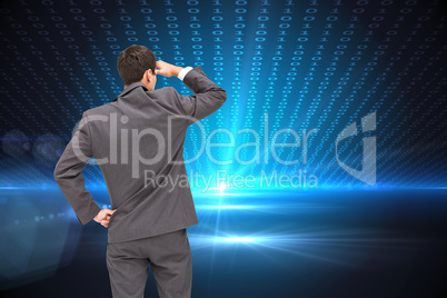 Composite image of businessman standing hand on hip