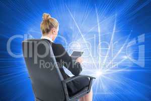 Composite image of businesswoman sitting on swivel chair with ta