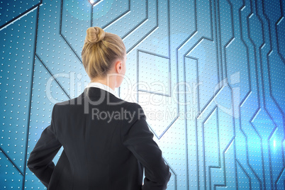 Composite image of businesswoman standing with hands on hips