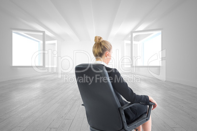 Composite image of businesswoman sitting on swivel chair in blac